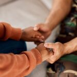 soldier in counselling man and woman holding hands vj6bejn